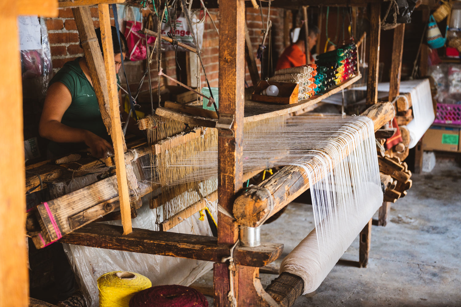 Weavers working on wooden loom hand making blankets