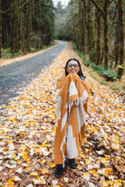 Orange blanket wrapped around girl on side of road