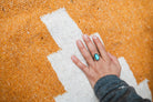 Orange handwoven blanket and hand with turquoise ring