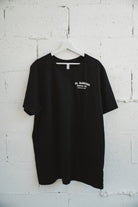 Black tshirt hanging on a white brick wall