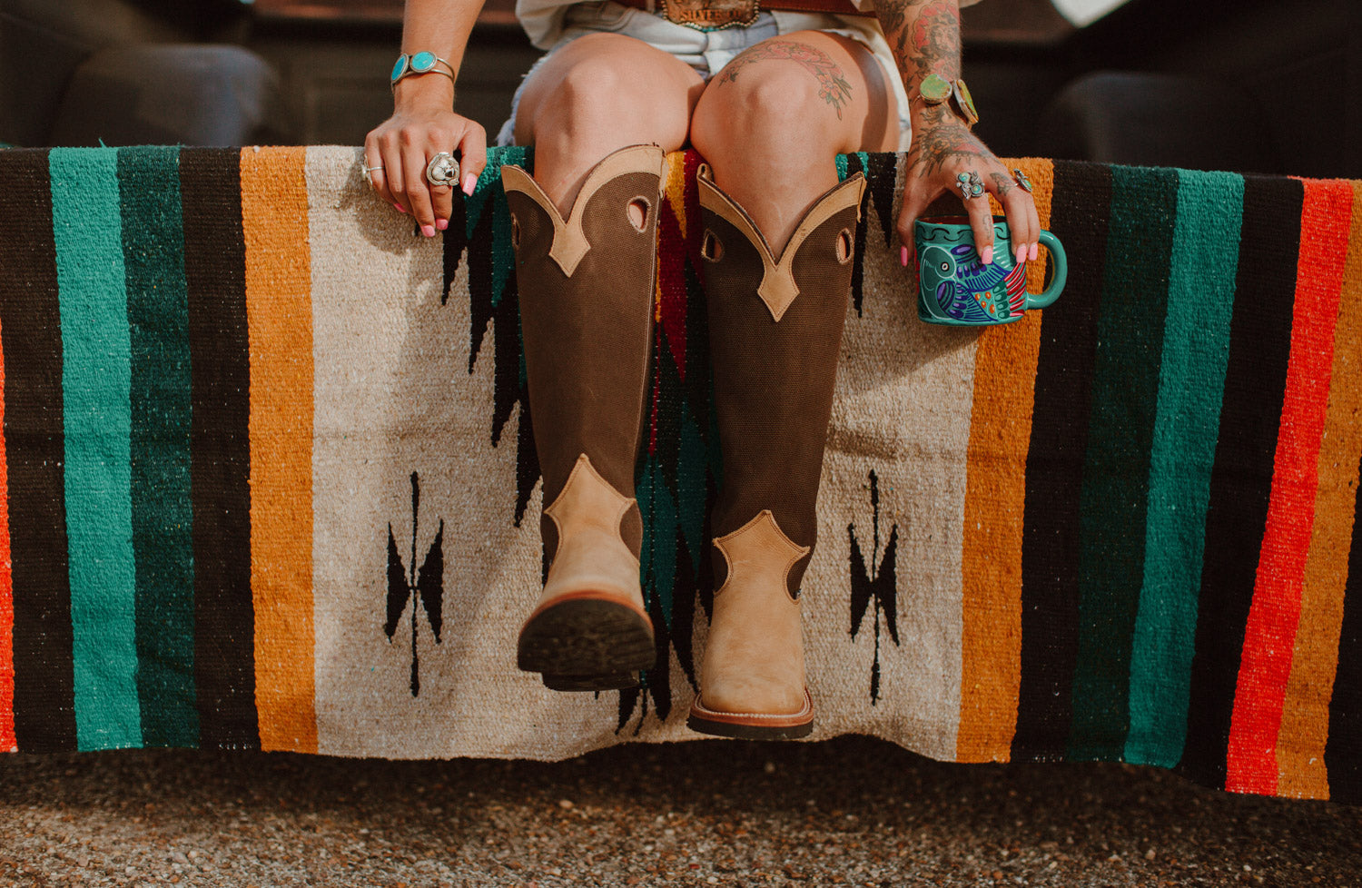 Girl sitting on diamond blanket in cowboy boots