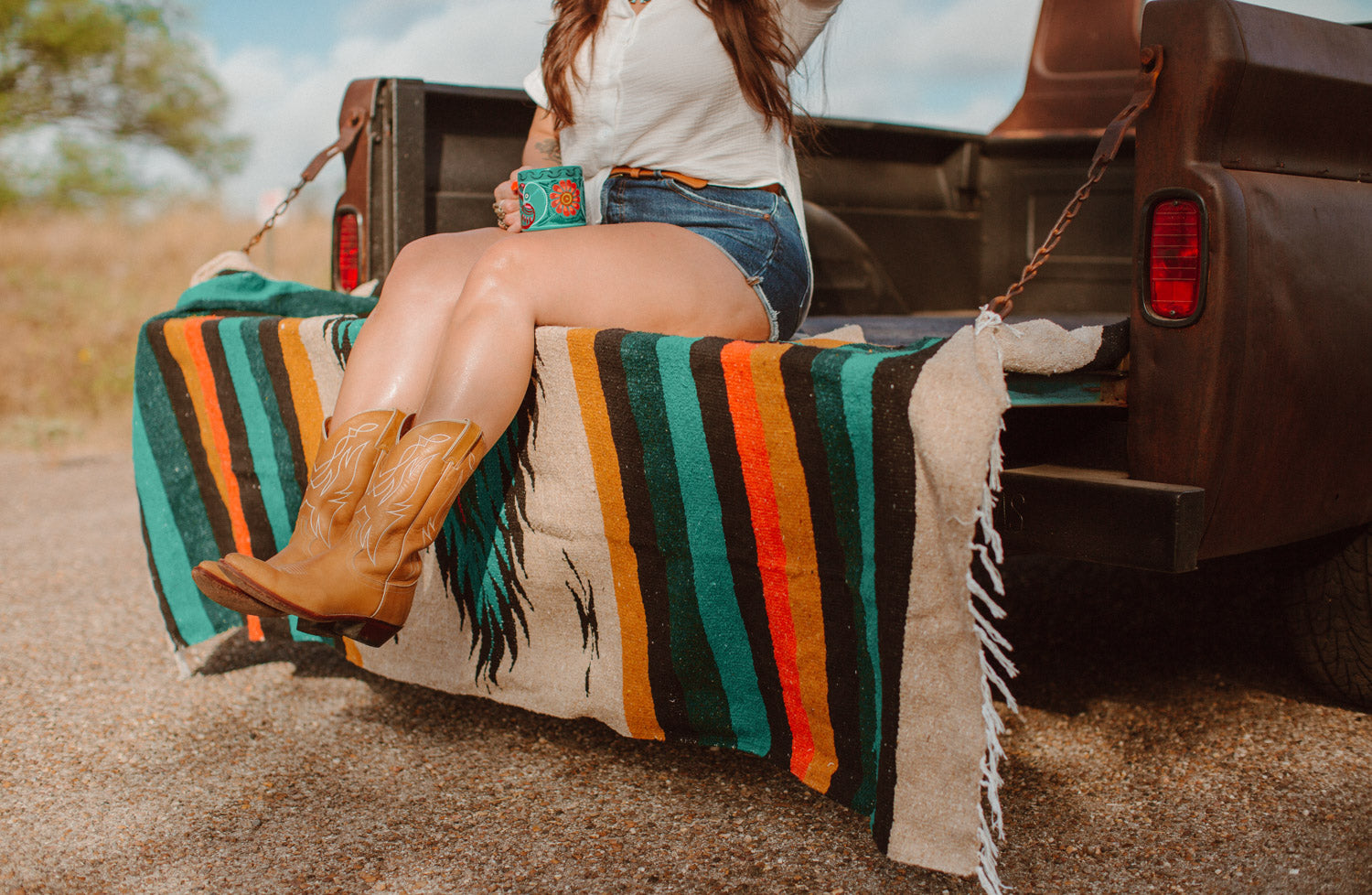 Girl sitting on diamond blanket in cowboy boots