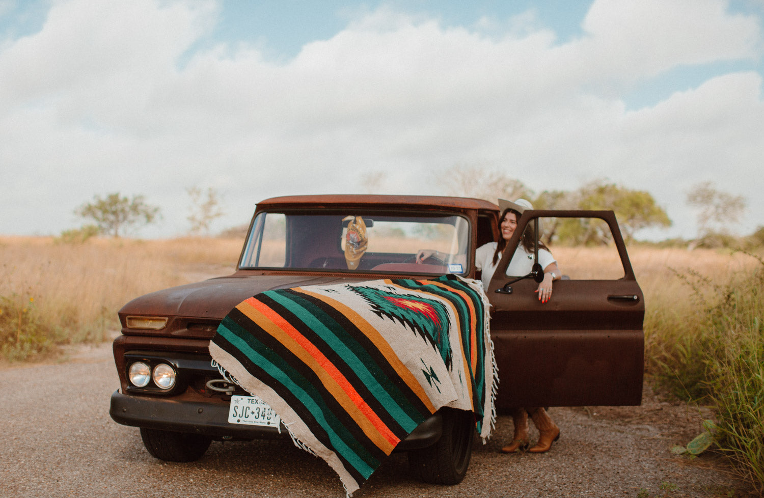 Diamond blanket sitting on the hood of a vintage pickup truck