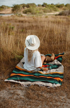 Girl sitting on diamond blanket in cowboy boots