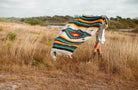 Girl spreading out diamond blanket in a field of tall dry grass