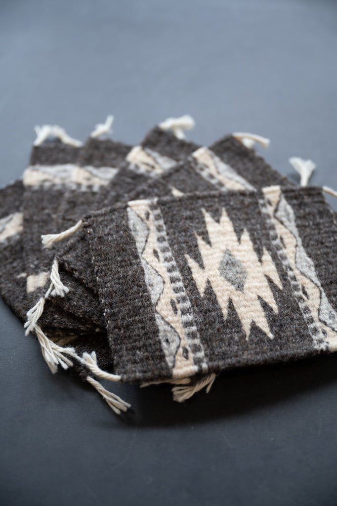 Neutral colored handwoven wool Zapotec coasters from Oaxaca on a black background