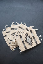 Neutral colored handwoven wool Zapotec coasters from Oaxaca on a black background