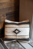 Neutral colored Handwoven Zapotec pillow shawl sitting on a couch corner