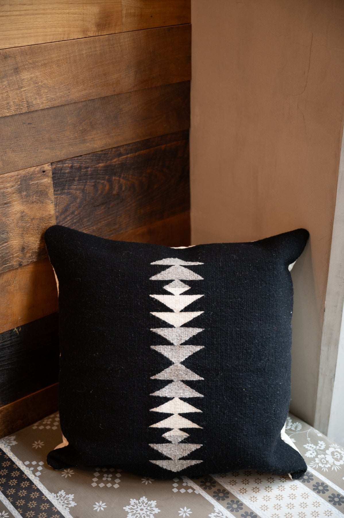 Neutral colored Handwoven Zapotec pillow shawl sitting on a couch corner