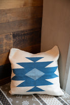 white and blue colored Handwoven Zapotec pillow shawl sitting on a couch corner