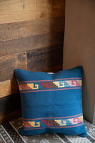 Navy blue colored Handwoven Zapotec pillow shawl sitting on a couch corner