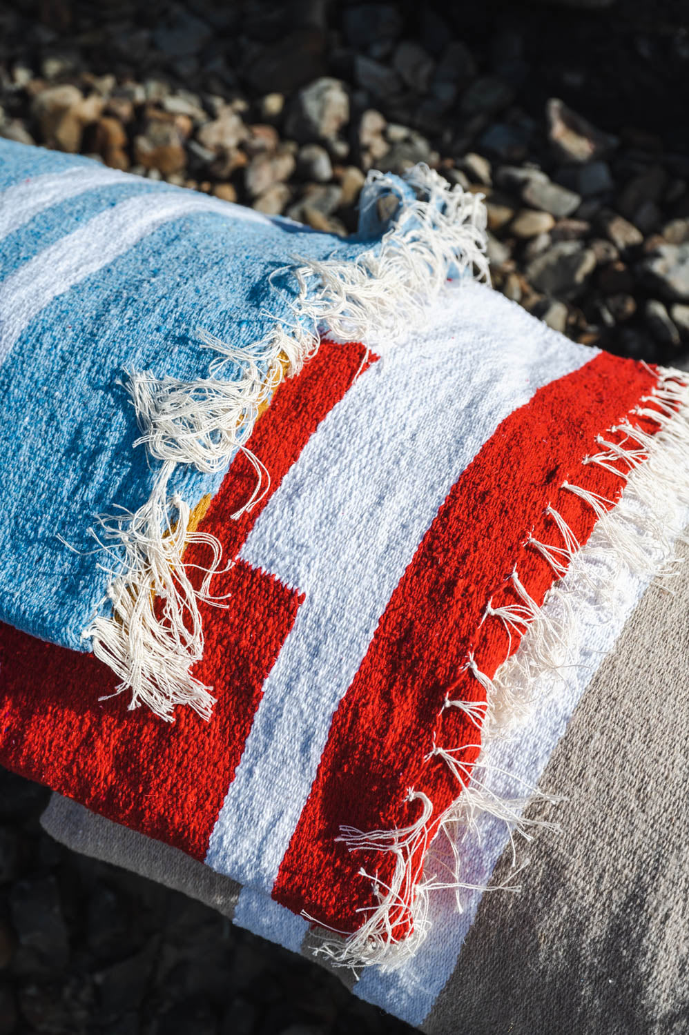 folded mexican blankets of red and blue colors