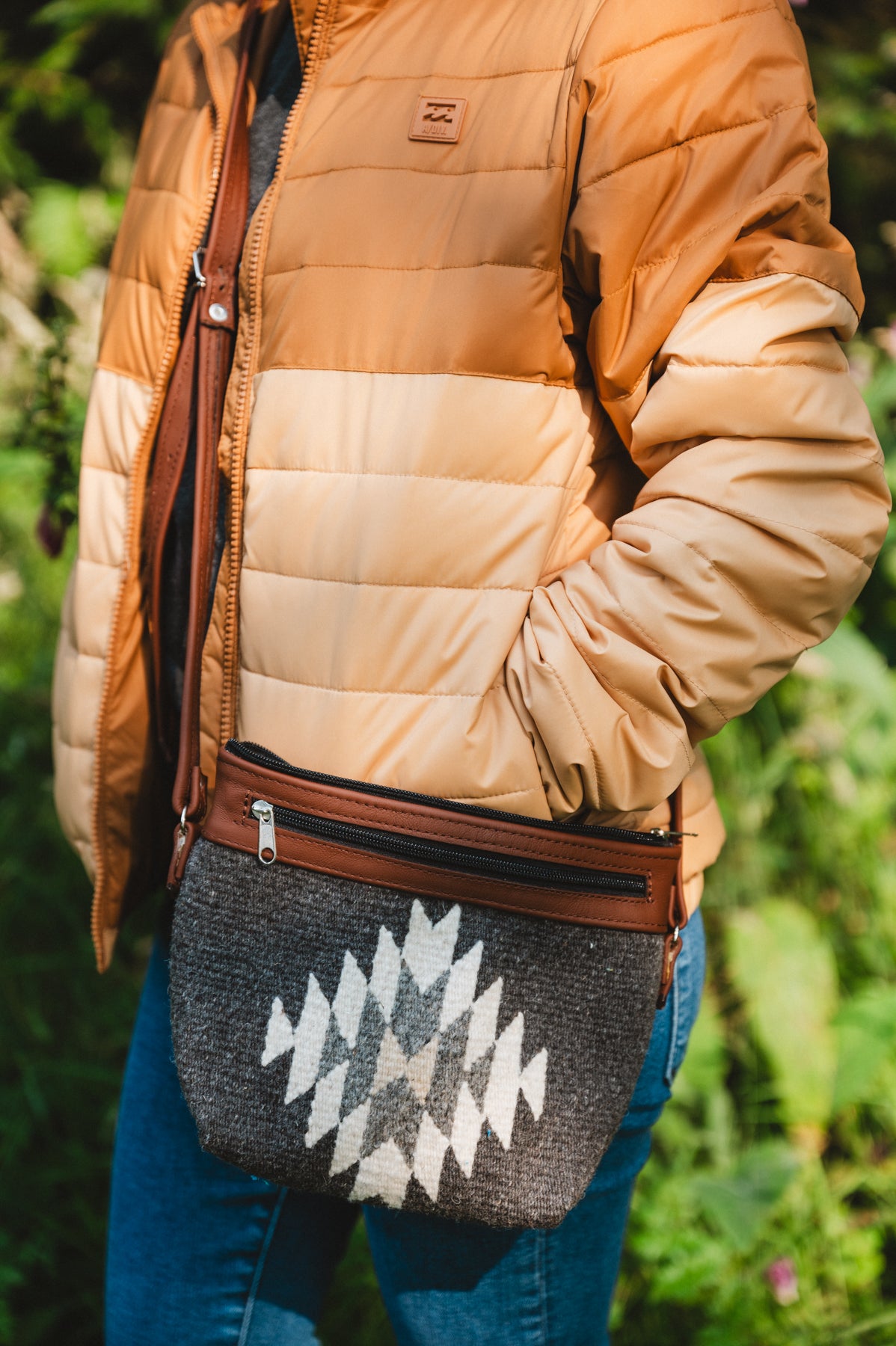 Charcoal colored handwoven wool purse being worn by girl in forest