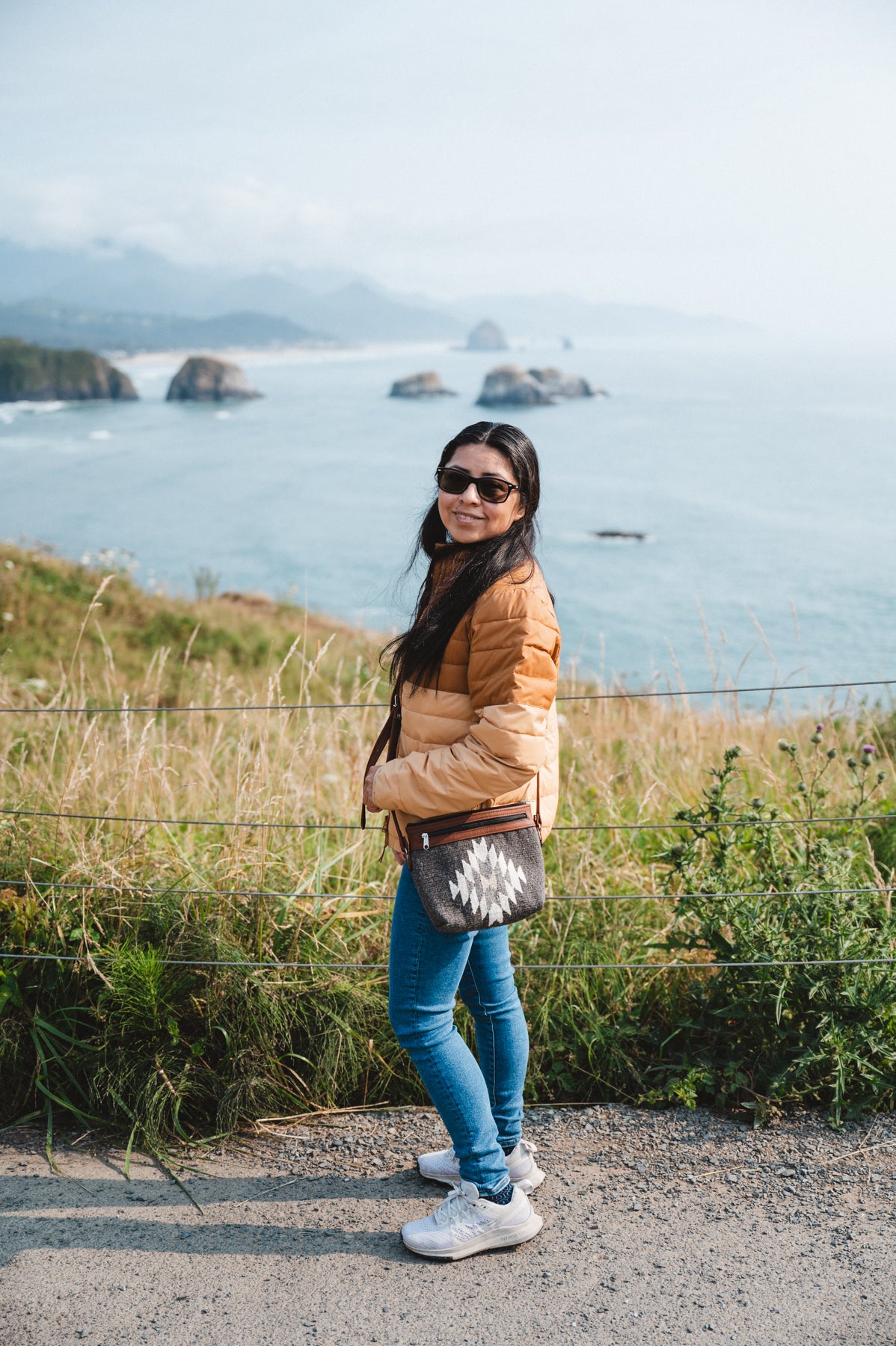 Charcoal colored handwoven wool purse being worn by girl at beach overlook