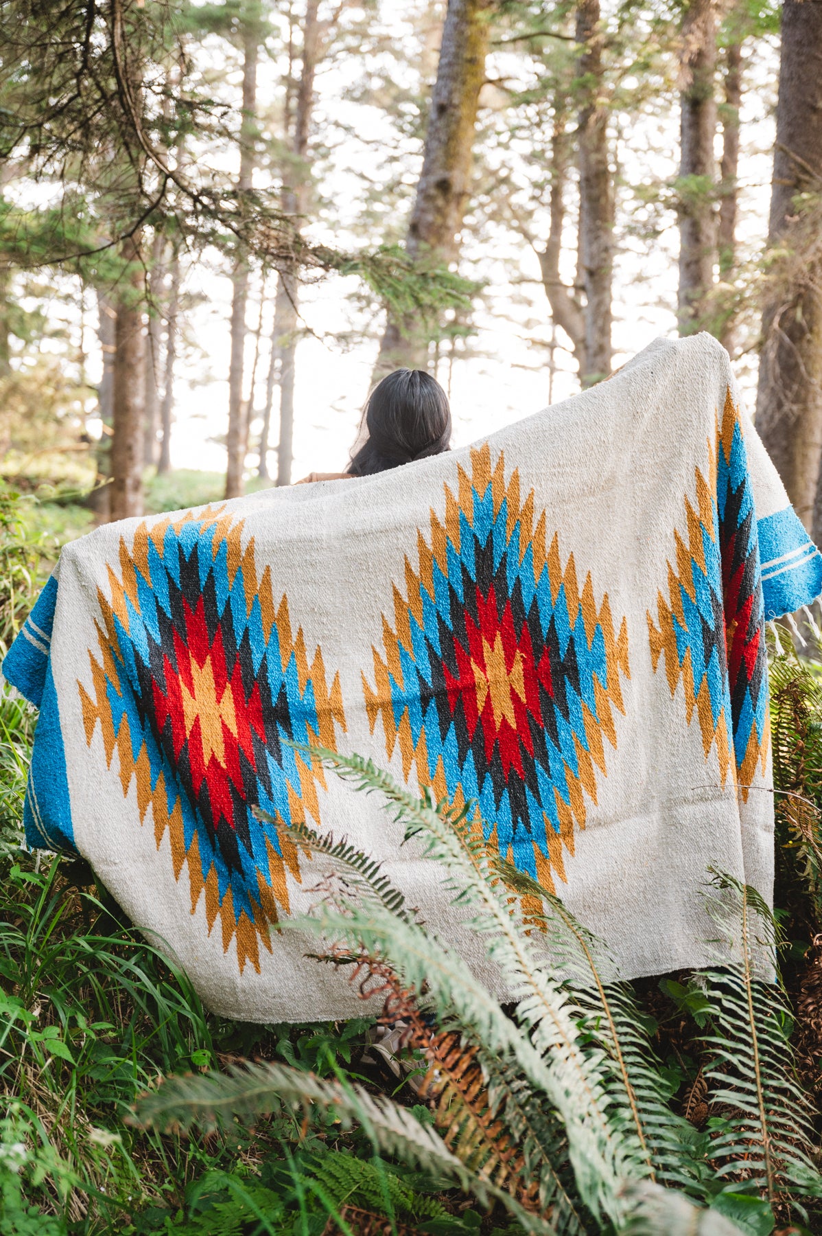 handwoven southwestern diamond sarape being worn by girl in forest