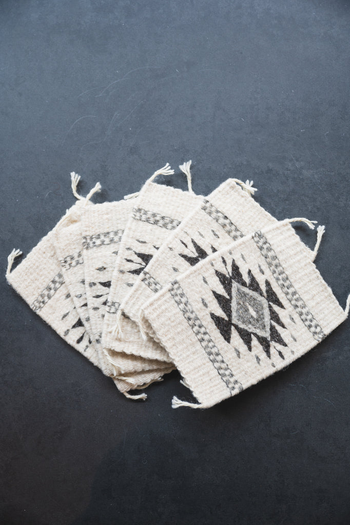 Neutral colored handwoven wool Zapotec coasters from Oaxaca on a black background