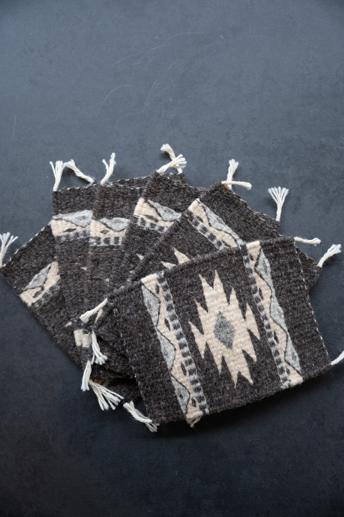 Neutral colored handwoven wool Zapotec coasters from Oaxaca on a black background