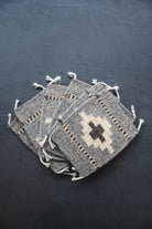 Neutral colored handwoven wool Zapotec coasters from Oaxaca on a black background