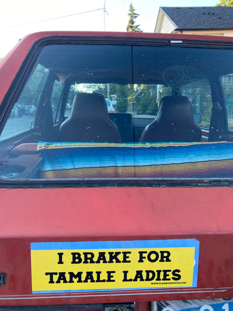 "I brake for tamale ladies" yellow and black bumper sticker on a red car