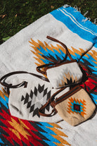 Mexican wool purses laying on top of a handwoven mexican blanket