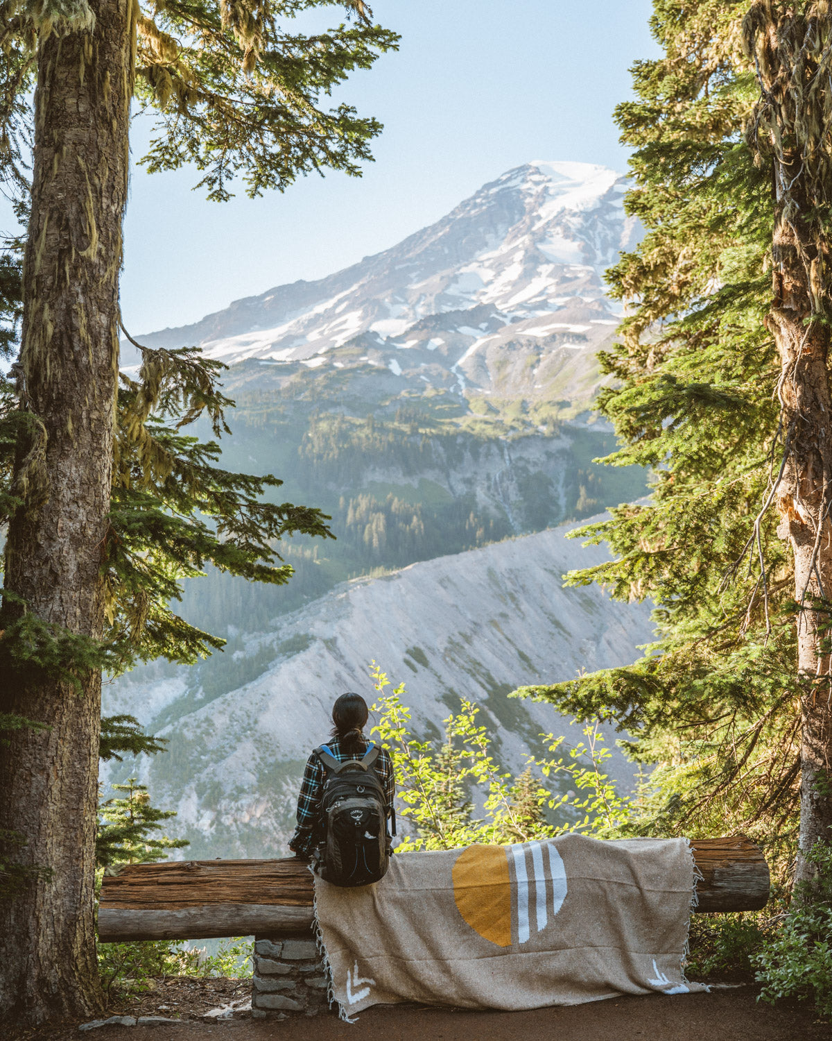 Woman sitting on blanket looking at mount rainier