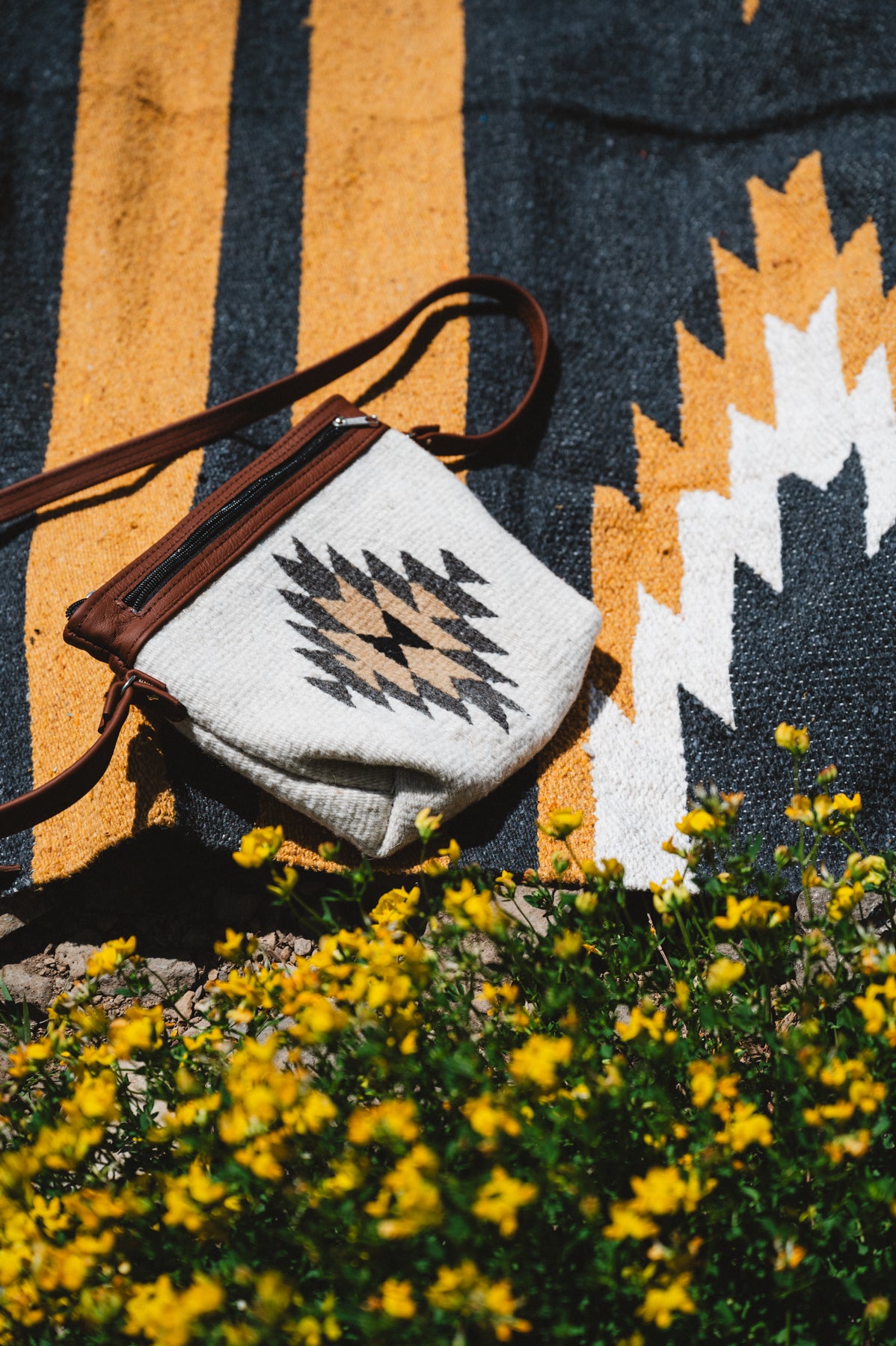 yellow zapotec diamond wool purse laying on relampago design mexican blanket