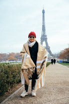 woman wearing tan mexican blanket in front of eiffel tower